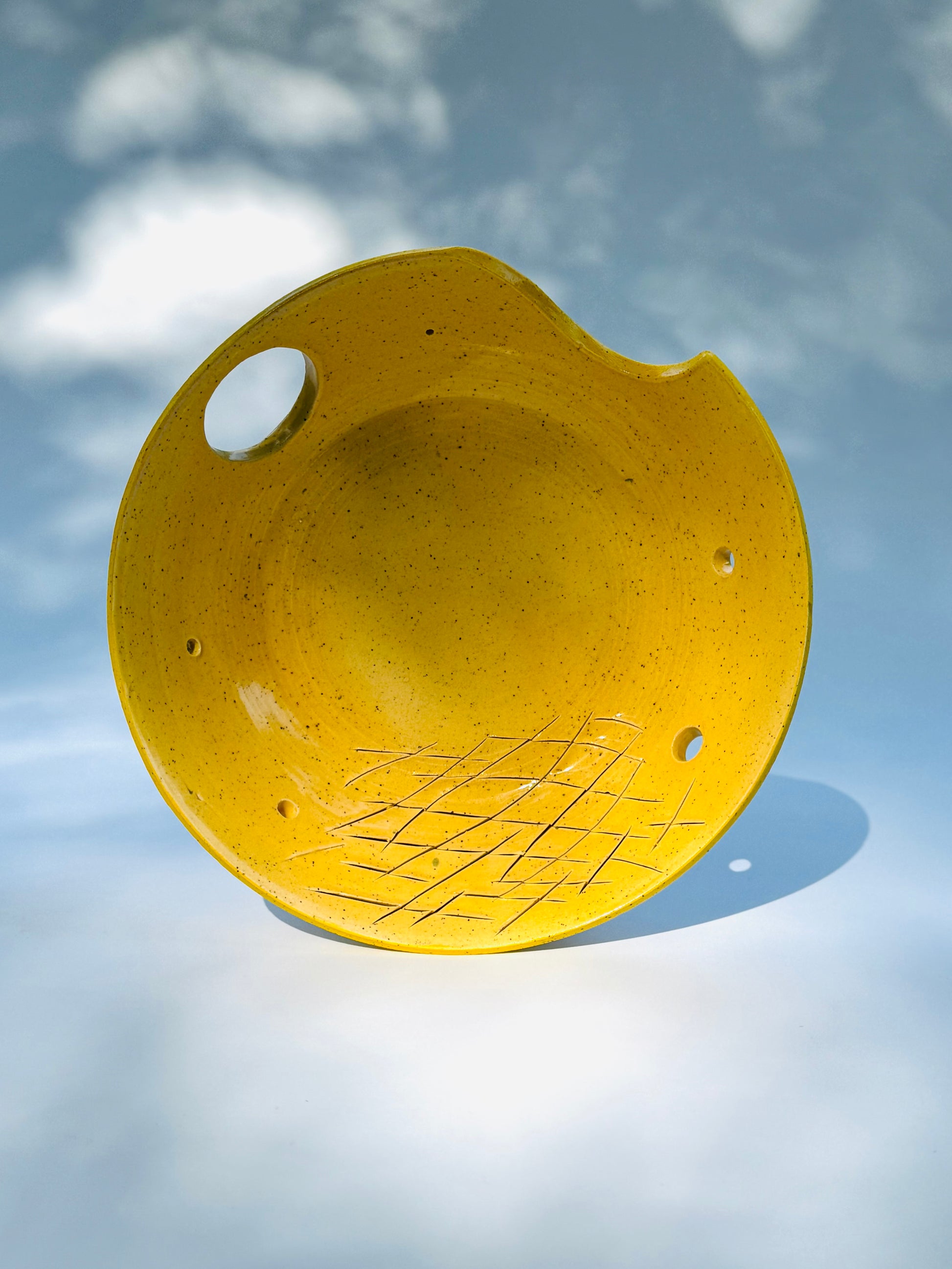 Interior bowl view of the classic yellow two thumb hole herb stripper with Garlic Grater by Rita Strayer Ceramics of Savannah. Easily strip leaves of your favorite herb. Stoneware clay.