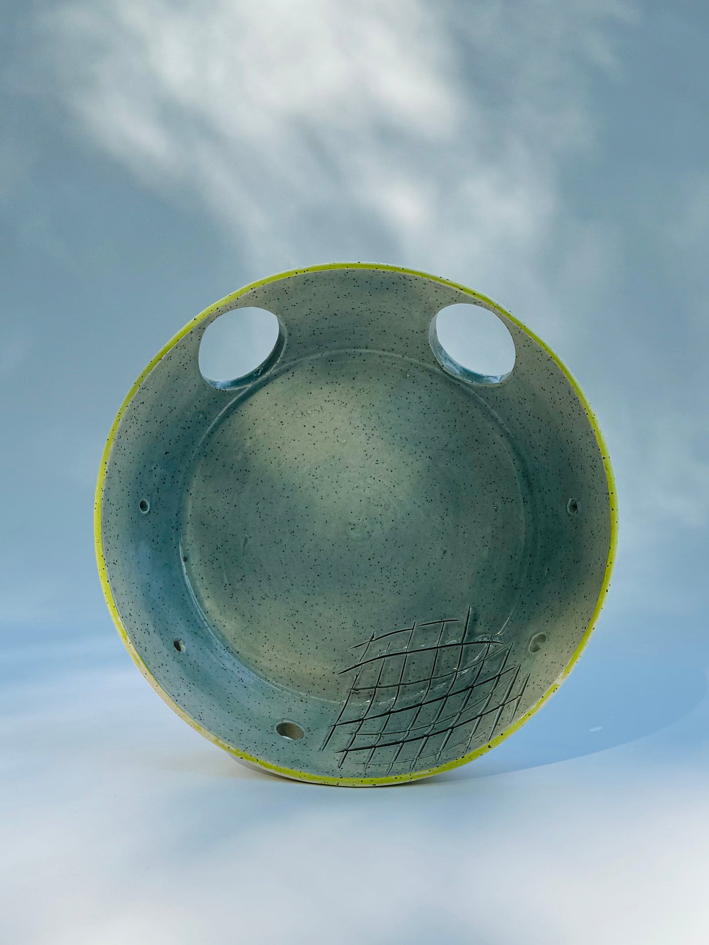 Propped up view of the classic chartreuse herb stripper with garlic grater by Rita Strayer Ceramic Savannah. Now featuring two thumb holes to give you better control as you easily strip leaves from your favourite herbs. Stoneware clay material.