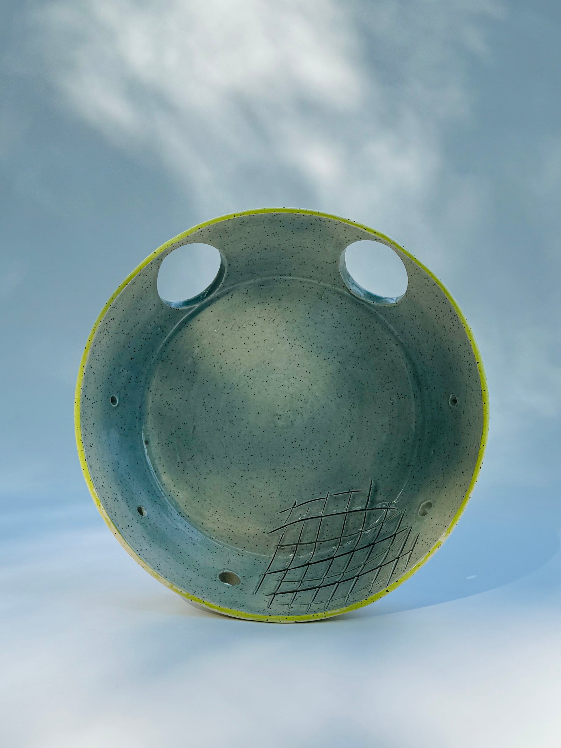 Propped up view of the classic chartreuse herb stripper with garlic grater by Rita Strayer Ceramic Savannah. Now featuring two thumb holes to give you better control as you easily strip leaves from your favourite herbs. Stoneware clay material.