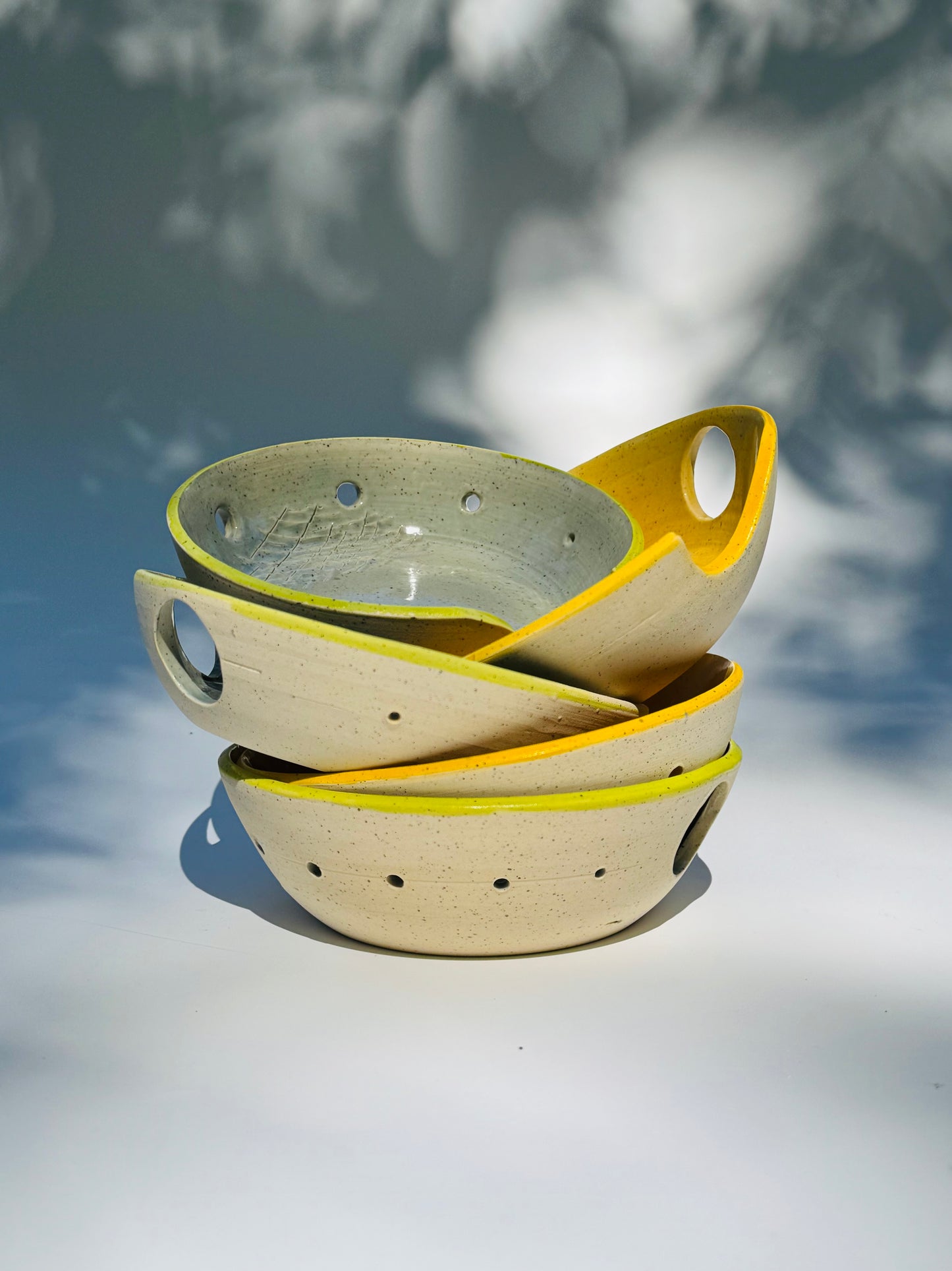Stacked view of five different Herb stripper with Garlic Grater designs by Rita Strayer Ceramics of Savannah. Easily strip leaves from your favorite herb. Made from Stoneware clay. Thumb holes and/or grooves allow for easier control as you use it. Color choices include chartreuse (green) or yellow.