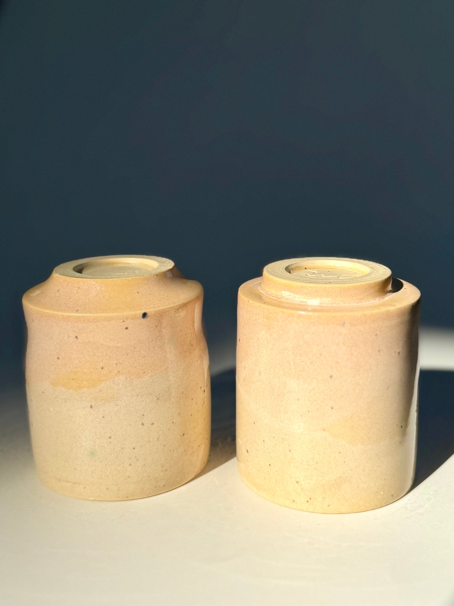 Upside down view of the unique Subtle Speckles Grooved Cup (left) and the Subtle Speckles Straight Cup (right) from Rita Strayer Ceramics Savannah. Perfectly tasteful little 6oz tumblers. Very faint speckle pattern appears throughout the clay mix.